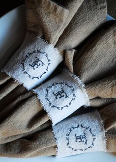 napkins with embroidered faces on them sitting on a plate