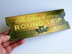 a person holding up a gold ticket for the royal express's round trip,