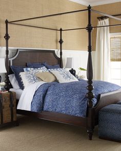 a bedroom with a four post bed and blue comforter