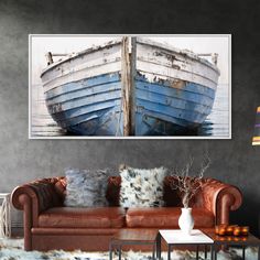 a living room with a brown couch and a blue boat on the wall above it