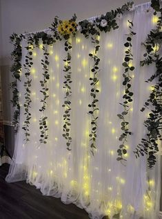 the curtain is decorated with flowers and greenery for an indoor wedding ceremony or party