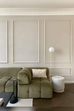 a living room with a green couch and white walls