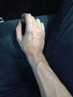 black and white photograph of a person's hand on the arm of a couch