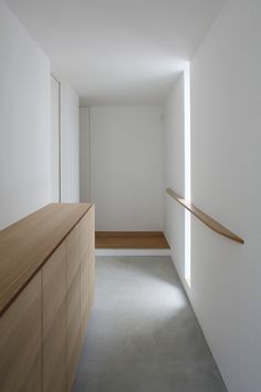 an empty room with white walls and wood furniture