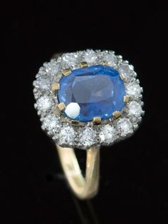 Bewithcing blue Sophisticated elegance and classic style featuring a vibrant, silky cornflower blue natural no heat Ceylon sapphire reminiscent of a celestial sky highlighted by sparkling diamonds.  Dress to impress with this Vintage natural, no heat, Ceylon sapphire and diamond cluster ring.  Heavenly in its totality, this gemstone will mesmerize and entrance. The eye can travel through the stone or pause on the surface or get lost among the refraction and reflections.  Boasting is an evocative Blue Luxury Diamond Ring With Rose Cut Diamonds, Luxury Blue Diamond Ring With Rose Cut, Timeless Blue Sapphire Ring Gia Certified, Timeless Gia Certified Blue Sapphire Ring, Timeless Blue Cushion Cut Ring, Heirloom Blue Cushion Cut Rings, Gia Certified Timeless Blue Ring, Heirloom Blue Sapphire Ring With Rose Cut Diamonds, Blue Cluster Rings In Classic Style