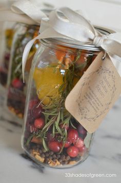 two mason jars filled with different types of fruit and veggies, tied with a white ribbon