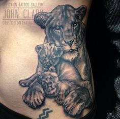 a woman with a lion tattoo on her stomach and two kittens in the belly