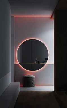 a round mirror on the wall above a stool in a room with wooden flooring