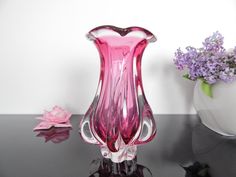 a pink glass vase sitting on top of a table