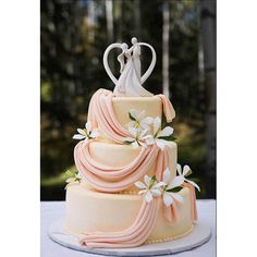 a wedding cake decorated with flowers and a bride and groom figurine on top