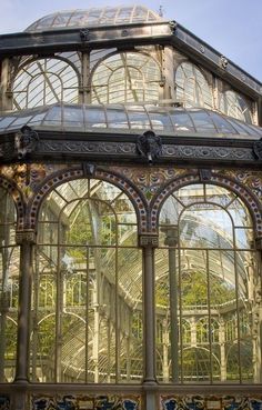 the inside of a glass house with lots of windows on each side and an arched roof