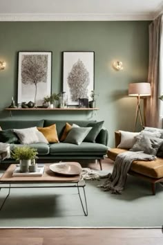 a living room with green walls and furniture in the center, two pictures on the wall