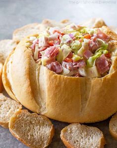 a bread bowl filled with lots of different types of toppings on top of crackers