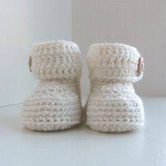 These button cuff baby booties will quickly become your go-to pattern. They have a classic, simple style that make a sweet gift for any baby. Best of all, they work up quickly, in one piece, with no seams and they leave room for your own creativity! Skill Level Easy - Projects using yarn with basic stitches, repetitive stitch patterns, simple color changes, and simple shaping and finishing.Sizes0-6 months & 6-12 monthsFinished Measurements0-6 months (9 cm long), 6-12 months (10 cm long)Mater Crochet Wrap Pattern, Repeat After Me, Patterns Simple, Baby Booties Pattern, Basic Stitches, Booties Shoes, Sport Weight Yarn, Download Button, Sweet Gifts