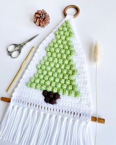 a crocheted christmas tree decoration with scissors and yarn