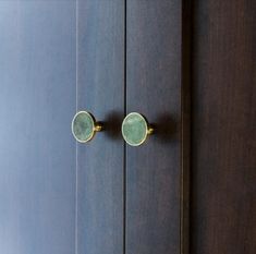 two green doors with brass handles and knobs