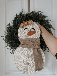 a snowman made out of rope is hanging on the door