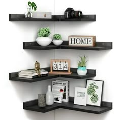 three black shelves with books, plants and pictures on them