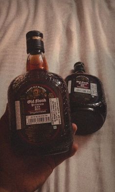 two bottles of maple syrup sitting on top of a white bed sheet next to each other