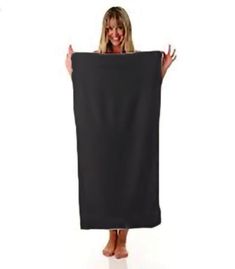 a woman is holding up a black towel