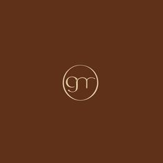 the letter m is inscribed in a circle on a brown background with a white outline