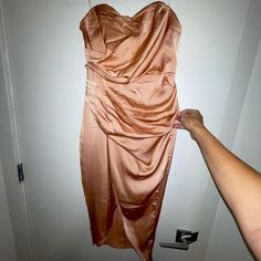 a woman is holding up a dress hanging on the wall