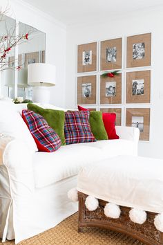 a living room filled with white furniture and pictures on the wall behind it's back