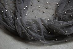 an image of a scarf with pearls on the bottom and black fabric around it that looks like something out of space