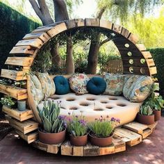 a couch made out of wooden pallets with plants and potted cacti