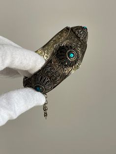 Very beautiful silver bracelet, inside and outside with an ornamental pattern and six incorporated circles with blue stones. The bracelet is closed with an iron rod on a chain. Stable and has good condition. Material: Metal, Plastic Size: around hand 17 cm Ornate Metal Bracelets For Festival, Ornate Silver Metal Bracelet, Ornate Sterling Silver Bracelet With Intricate Design, Ornamental Pattern, Ladies Bracelet, Medieval Style, Blue Stones, Medieval Fashion, Viking Jewelry