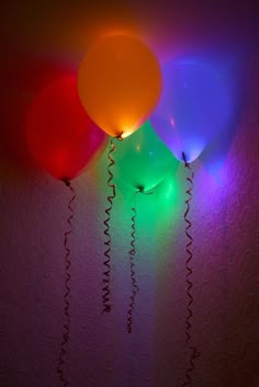 three balloons that are glowing in the dark