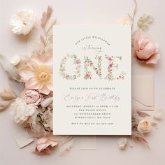 the floral wedding stationery is surrounded by flowers