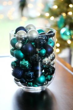 a glass bowl filled with ornaments on top of a table