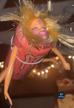 a doll with blonde hair is flying through the air