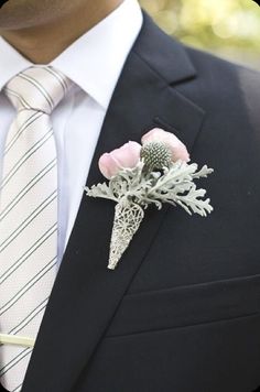 a man wearing a suit and tie with flowers in his lapel flower pin on the lapel