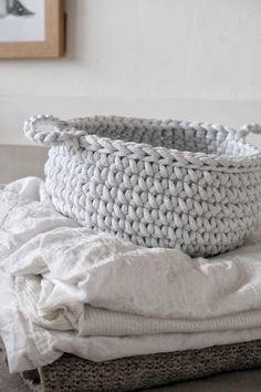 a white basket sitting on top of a bed