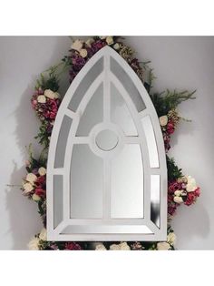 an arched mirror with flowers around it