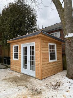 a small wooden shed sitting next to a tree