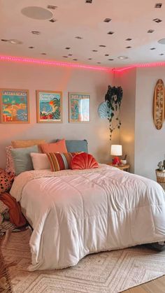 a bed sitting in a bedroom next to two lamps and pictures on the wall above it