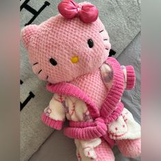 a pink hello kitty stuffed animal laying on top of a bed