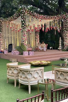 a man sitting on a chair in front of a stage set up for a wedding