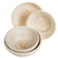 three white bowls are stacked on top of each other, one has a flower in the center