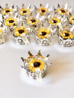 a group of sunflowers sitting on top of each other in small silver cups