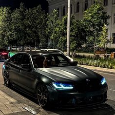 two cars are parked on the side of the road at night time in front of an apartment building