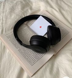 an open book with headphones on top of it