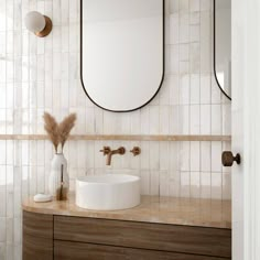 a bathroom sink with two mirrors above it