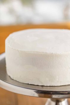 a white cake sitting on top of a metal plate