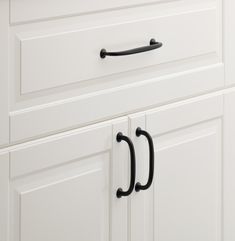 a kitchen cabinet with two black handles on it