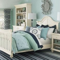 a bedroom with blue walls and white furniture