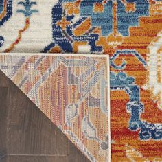 an orange, blue and white rug with different colors on the floor next to each other